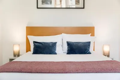 a bedroom with a white bed with two blue pillows at Apartment Bolhao Market by Sweet Porto in Porto
