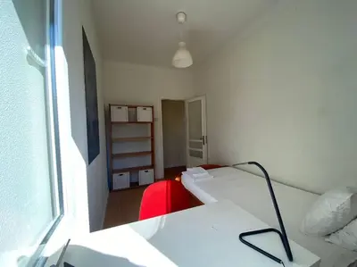 a bedroom with a bed and a desk and a window at Casa do Carmo in Porto