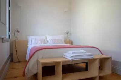 a bedroom with a bed with a table with towels on it at CL Ildefonso I Apartment in Porto