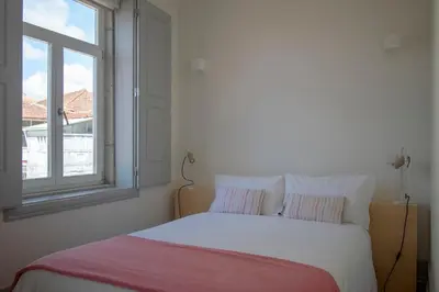 a bedroom with a white bed with a window at CL Ildefonso I Apartment in Porto