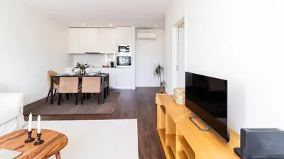 a living room with a television and a table at 2BR Wonder in the City Center by LovelyStay in Porto