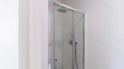 a shower with a glass door in a bathroom at 2BR Wonder in the City Center by LovelyStay in Porto