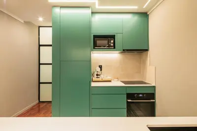 a kitchen with green cabinets and a sink at Porto Insight Apartments- with balcony in Porto