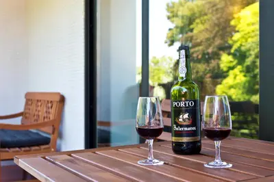 a bottle of wine sitting on a table with two glasses at VIVA Belos Ares in Porto