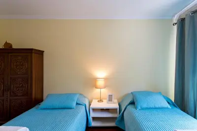 a bedroom with two beds and a table with a lamp at VIVA Belos Ares in Porto