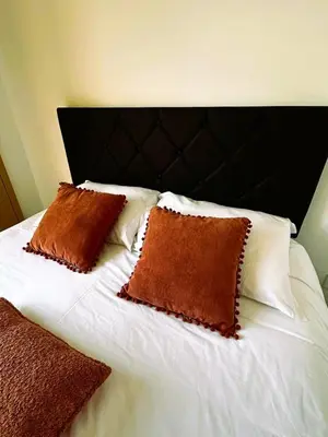 a bed with two brown pillows on top of it at Alma de Cedofeita Apartment in Porto