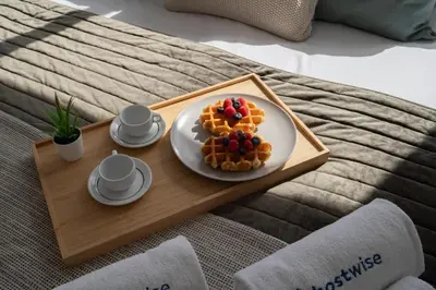 a plate of waffles on a tray on a bed at Host Wise - Sunny Bright Flat w Balcony in Porto