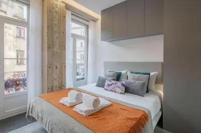 a bedroom with a large bed with towels on it at Ribeira Apartments Baixa in Porto