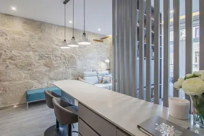 a kitchen with a counter and chairs in a room at Ribeira Apartments Baixa in Porto