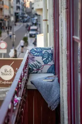 a balcony with pillows on a building with a street at Ribeira Apartments Baixa in Porto