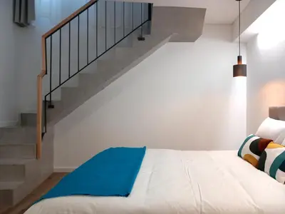 a bedroom with a bed and a staircase at Fontinha House in Porto