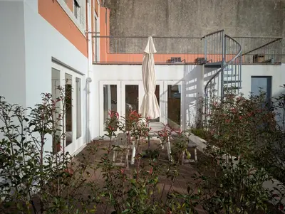 a white building with an umbrella on a balcony at dvnest - Premium 1BR Apartment Designed for Remote Work in Porto