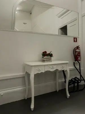 a white dressing table with a mirror and flowers on it at Antero de Quental Studios 2 in Porto
