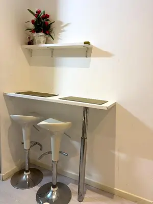 a white counter with two stools and a table at Antero de Quental Studios 2 in Porto