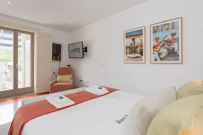 a white bedroom with a bed and a window at Liiiving in Porto - Trindade Deluxe Studios in Porto