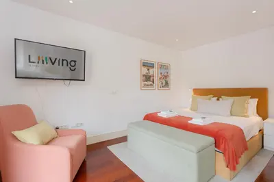a bedroom with a bed and a couch and a chair at Liiiving in Porto - Trindade Deluxe Studios in Porto