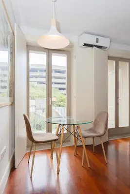 a dining room with a glass table and two chairs at Liiiving in Porto - Trindade Deluxe Studios in Porto