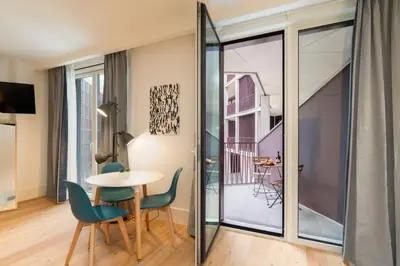 a room with a table and chairs and a window at Urban Stylish Studio with Balcony in Porto