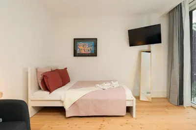 a bedroom with a bed and a tv on a wall at Urban Stylish Studio with Balcony in Porto