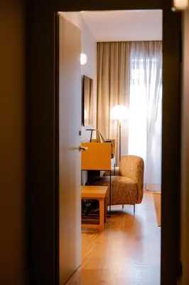 a living room with a chair and a desk in a room at Casa Zogbi Hotel in Porto