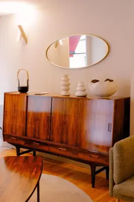 a mirror on top of a wooden dresser in a living room at Casa Zogbi Hotel in Porto