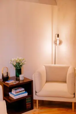 a living room with a white chair and a table at Casa Zogbi Hotel in Porto