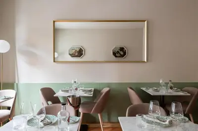 a dining room with tables and chairs and a mirror at Casa Zogbi Hotel in Porto