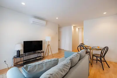 a kitchen and living room with a couch and a table at Porto Living | 1BR Flat with AC in Porto