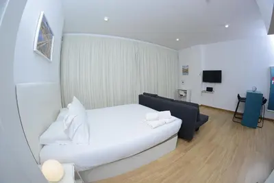 a hotel room with a white bed and a couch at Bonsai Apartment 6 in Porto