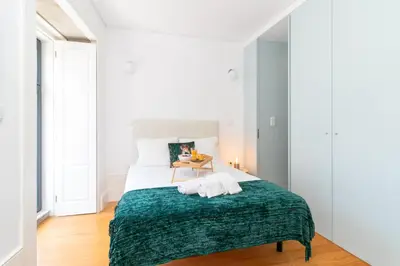 a bedroom with a bed with a green blanket at Formosa Studios by Upperground in Porto