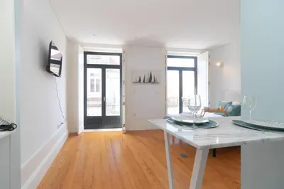 a white living room with a table and a door at Formosa Studios by Upperground in Porto