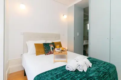a bedroom with a white bed with towels on it at Formosa Studios by Upperground in Porto