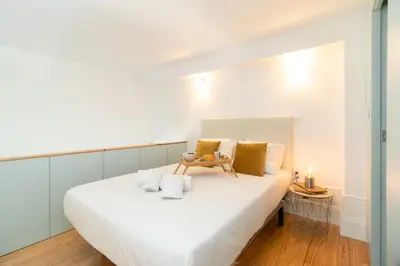 a bedroom with a large white bed with yellow pillows at Formosa Studios by Upperground in Porto