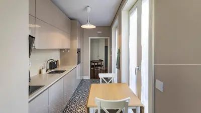 a small kitchen with a wooden table and chairs at Cardosas Spacious Studio by LovelyStay in Porto