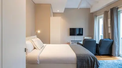 a hotel room with a bed and a tv at Cardosas Spacious Studio by LovelyStay in Porto