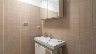a bathroom with a white sink and a mirror at Cardosas Spacious Studio by LovelyStay in Porto
