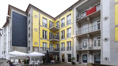 a group of buildings with tables and umbrellas at Cardosas Spacious Studio by LovelyStay in Porto