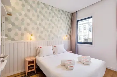 a bedroom with a white bed with two pillows on it at Oporto Vibes - T1 Moderno no Centro do Porto com AC, by HopStays in Porto