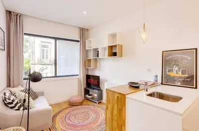 a kitchen with a sink and a living room at Oporto Vibes - T1 Moderno no Centro do Porto com AC, by HopStays in Porto