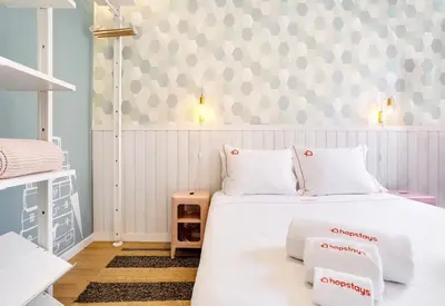 a bedroom with a white bed and a patterned wall at Oporto Vibes - T1 Moderno no Centro do Porto com AC, by HopStays in Porto