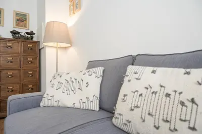 a gray couch with two pillows on it with a lamp at GuestReady - Oporto Vintage in Porto