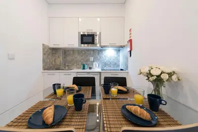 a kitchen with a table with plates of bread on it at O Herculano Porto in Porto