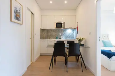 a kitchen and dining room with a table and chairs at O Herculano Porto in Porto
