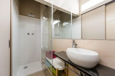 a bathroom with a white sink and a shower at GuestReady - A charming duplex home near Boavista in Porto