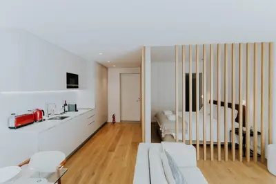 a living room with white furniture and a bedroom at VIVA Formosa Lofts in Porto
