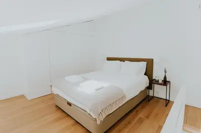 a bedroom with a bed with white sheets at VIVA Formosa Lofts in Porto