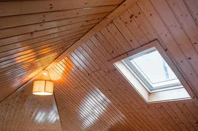 a light and a window in a wooden ceiling at GuestReady - Charming Mezzanine near Porto in Vila Nova de Gaia