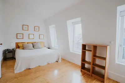 a white bedroom with a bed and two windows at VIVA Contemporary Duque Terceira in Porto
