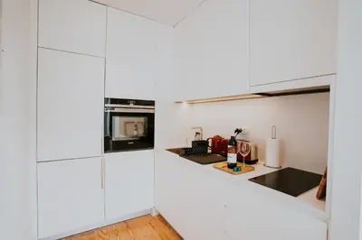a kitchen with white cabinets and a counter top at VIVA Contemporary Duque Terceira in Porto