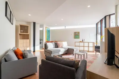 a living room with couches and a flat screen tv at Host Wise - Bright and Cozy House with Dom Luís Bridge View in Porto